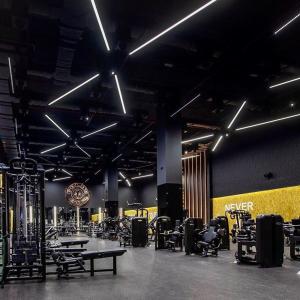 a gym with chairs and tables and a clock on the wall at 2BR Modern & Comfy Apartment in luxury neighbourhood in Madinaty