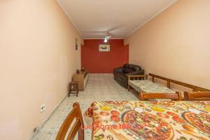 uma sala de estar com duas camas e um sofá em Apartamento em Praia Grande a 600 metros do mar na Praia Grande