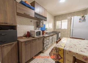 uma cozinha com um frigorífico e uma mesa em Apartamento em Praia Grande a 600 metros do mar na Praia Grande mais 27 fotografias