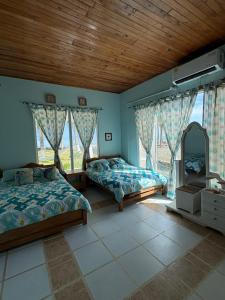 Un dormitorio con dos camas y una gran ventana. en San Bernardo del Viento Cabaña La Isabela, en San Bernardo del Viento