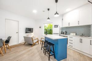 una cucina con armadi bianchi e isola blu di Seaside Victor Harbour Apartment a Victor Harbor