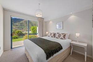 a bedroom with a large bed and a large window at Marina Edge Marlborough Sounds Apartment in Waikawa