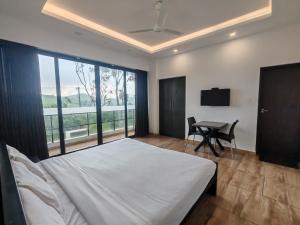 a bedroom with a bed and a desk and a television at Winter Woods in Vagamon