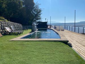 a swimming pool on a deck with chairs and a table at Lodge Colbún in Colbún Alto