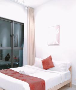 sypialnia z łóżkiem z białą pościelą i czerwonymi poduszkami w obiekcie Trion KL Family Suite 2Bedroom,2 Bathroom By Muchies w Kuala Lumpur +12 zdjęć