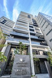 a tall building with a sign in front of it at Apartment Hotel 11 Nambaminami 2 in Osaka