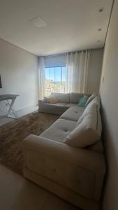a living room with two white couches and a window at Apê da Bella seu refúgio no Caparaó in Alto Caparao +5 photos