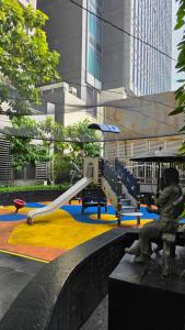un parc avec une aire de jeux avec un toboggan dans l'établissement Relaxing Luxury Stay in Makati, à Manille