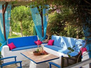 a blue couch with red pillows on a patio at Villa Nantia in Agios Georgios