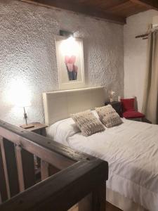 a bedroom with a white bed and a red chair at " Departamento Avenida" a 3 cuadras de la laguna y 3 del centro in Chascomús