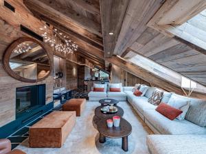 ein Wohnzimmer mit Sofa und Tisch in der Unterkunft Penthouse alpin moderne à Méribel, 12 pers., cheminée, service hôtelier 5* - FR-1-613-136 in Les Allues