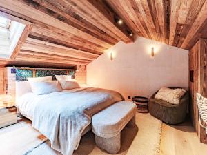 ein Schlafzimmer mit einem großen Bett und einem Stuhl in der Unterkunft Penthouse alpin moderne à Méribel, 12 pers., cheminée, service hôtelier 5* - FR-1-613-136 in Les Allues + 14 Fotos