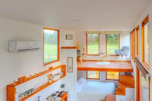 a room with a bed and a living room with windows at Refugio Campestre, Cabaña con Tinaja Opcional 