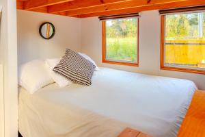 a bedroom with a white bed with two windows at Refugio Campestre, Cabaña con Tinaja Opcional 