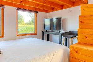 a bedroom with a bed and a tv and a desk at Refugio Campestre, Cabaña con Tinaja Opcional 
