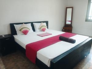 a bedroom with a large bed with a red blanket at Tiny Villa Homestay - ONLY FOR FOREIGN BOOKINGS in Kurunegala