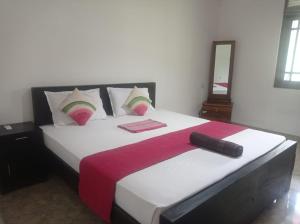 a bedroom with a large white bed with a red blanket at Tiny Villa Homestay - ONLY FOR FOREIGN BOOKINGS in Kurunegala
