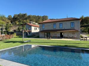 una villa con piscina frente a una casa en Quinta de Cartas, 