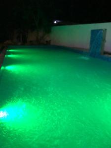 a pool filled with green water at night at Ovenro Hotel Yala, Kataragama in Kataragama