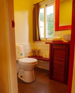 a bathroom with a toilet and a sink and a window at CASA DINIS -CASA GRANDE -CENTRO DE PORTOBELo in Portobelo +17 photos