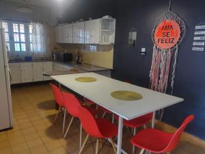 eine Küche mit einem weißen Tisch und roten Stühlen in der Unterkunft Casa Grande con pileta próximo kempes, ferial, Córdoba in Cordoba