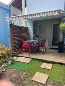a patio with a table and chairs in a yard at Studio Melisyle in Sainte-Anne