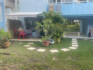 a yard with a patio with plants and a house at Studio Melisyle in Sainte-Anne