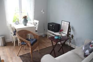 a living room with a couch and a tv and a table at Apartment Fleur de Lys Bleue in Soudaine-Lavinadière