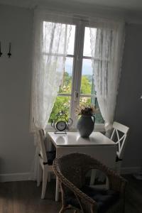a room with a table and a window with a vase on it at Apartment Fleur de Lys Bleue in Soudaine-Lavinadière