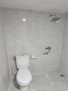 a bathroom with a white toilet and a shower at Batur Water Park Cabin in Kubupenlokan