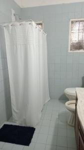 a bathroom with a white shower curtain and a toilet at La Casa del Colibrí in San Pedro +15 photos