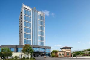 un edificio alto frente a un edificio en Microtel by Wyndham Anshun Xixiu, en Anshun