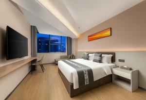 a hotel room with a large bed and a flat screen tv at Days Inn by Wyndham Zhuhai Qinglv Road in Zhuhai +13 photos