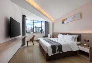 a hotel room with a large bed and a window at Days Inn by Wyndham Zhuhai Qinglv Road in Zhuhai