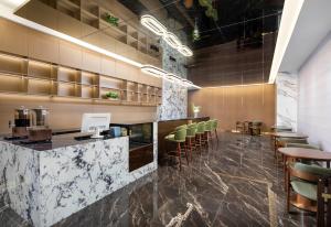a restaurant with a bar with green chairs at Days Inn by Wyndham Zhuhai Qinglv Road in Zhuhai