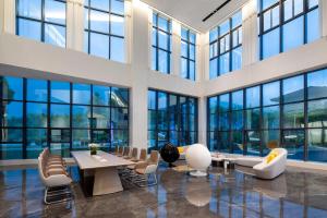 Una gran sala con mesas, sillas y ventanas. en Microtel by Wyndham Anshun Xixiu, en Anshun