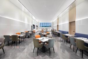 Un gran comedor con mesas y sillas. en Microtel by Wyndham Anshun Xixiu, en Anshun