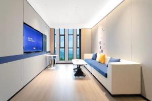 Una sala de estar con un sofá y un televisor. en Microtel by Wyndham Anshun Xixiu, en Anshun