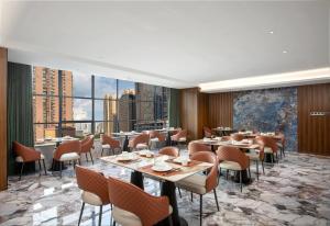 a restaurant with tables and chairs and a large window at Days Inn by Wyndham Changsha Yuanda Road in Changsha