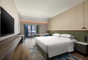 a bedroom with a large white bed and a flat screen tv at Days Inn by Wyndham Changsha Yuanda Road in Changsha +13 photos