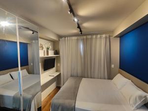 a hotel room with a bed and a television at Flat em São Paulo - Completo e Acolhedor in São Paulo +51 photos
