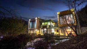 カピョンにあるGapyeong Rubino Pensionの夜間の緑灯が灯る大家