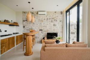 a kitchen and living room with a stone wall at Sawah Villas Pantai Lima in Pererenan