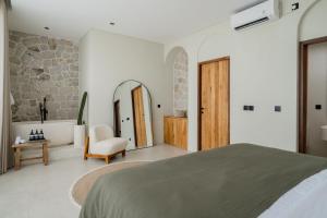 a bedroom with a bed and a stone wall at Sawah Villas Pantai Lima in Pererenan +49 photos