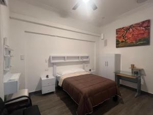 Un dormitorio con una cama, una mesa y un escritorio. en Alameda Suites & CAS - Centro Monterrey, en Monterrey