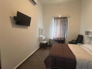 Una habitación de hotel con una cama y un televisor de pantalla plana. en Alameda Suites & CAS - Centro Monterrey, en Monterrey