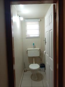 a small bathroom with a toilet and a window at The Deyzel house in Durban +22 photos