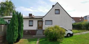 a white house with a car parked in the yard at Erdgeschoss Wohnung mit eigener Küche, Badezimmer und WC, inkl Gratis Frühstück, WiFi und Parkplatz, mit umzäunten Garten, Top Lage in Kassel, so privat wie zu Hause in Kassel
