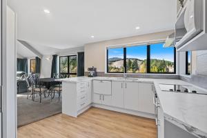 Una cocina con gabinetes blancos y una ventana grande. en Hanmer Haven, en Hanmer Springs