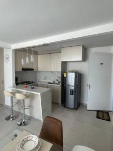 バジェドゥパルにあるApartamento NIZAのキッチン(冷蔵庫、テーブル、椅子付)